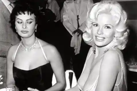 Sophia Loren Looking At Jayne Mansfield's 'Gown' At A Party - 1957